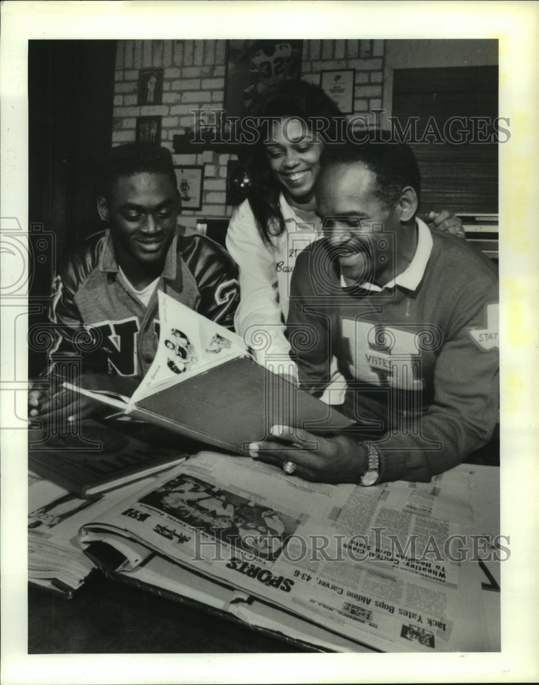 1988 Press Photo Grady Cavness Jr.; family check out dad&#39;s high school yearbook.- Historic Images