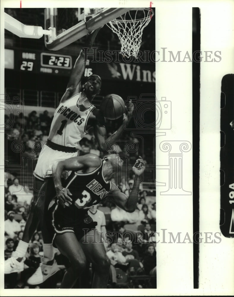 1989 Press Photo Rockets' Buck Johnson swings from rim to avoid Heats' Frank. - Historic Images