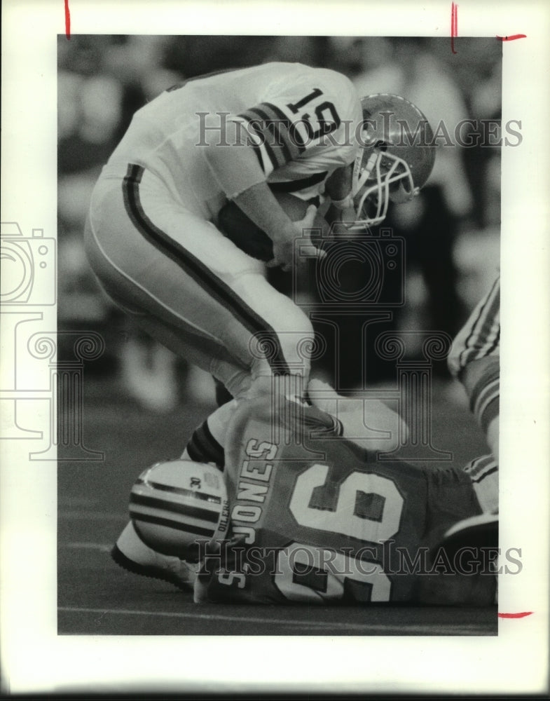 1990 Press Photo Browns quarterback Bernie Kosar is sacked by Oilers&#39; Sean Jones- Historic Images