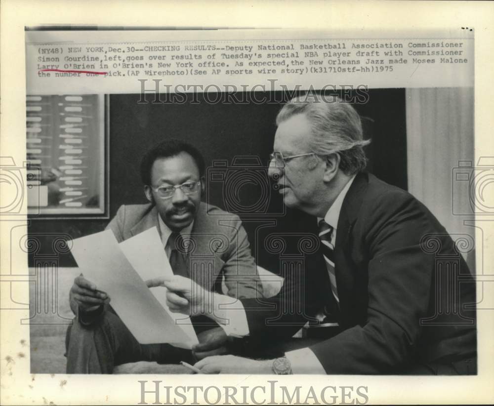 1975 Press Photo Simon Gourdine and Larry O&#39;Brien check NBA draft results, NY - Historic Images