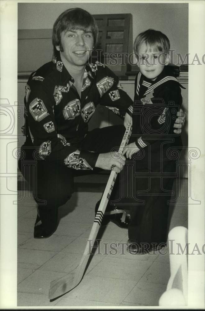 1974 Press Photo Houston Aeros' hockey star John Schella shows young fan how - Historic Images