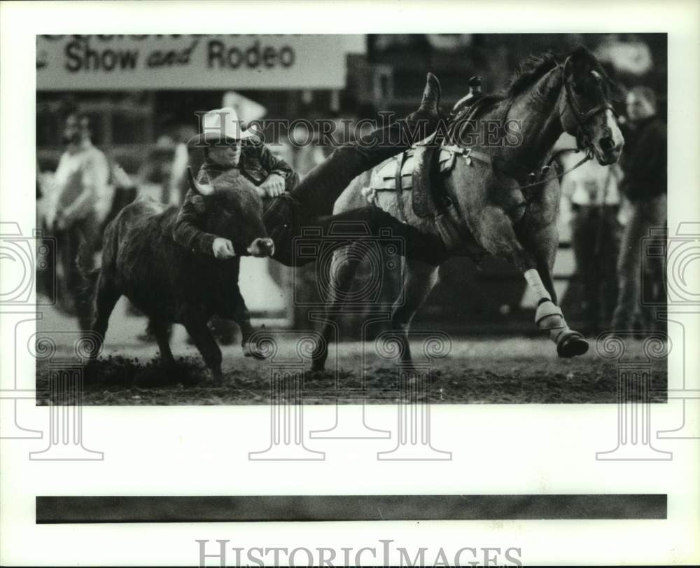 1991 Press Photo Steer wrestler Tim Little, Hackberry, LA. grabs steer by horns.- Historic Images