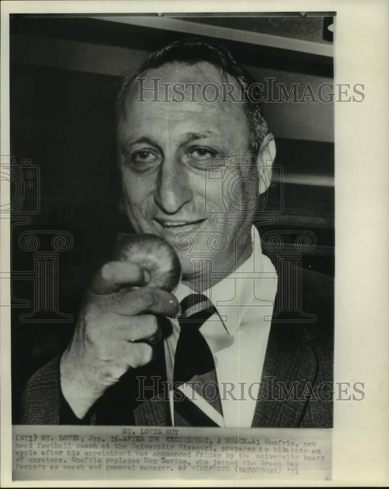 1971 New Missouri football coach Al Onofrio prepares to bite apple. - Historic Images
