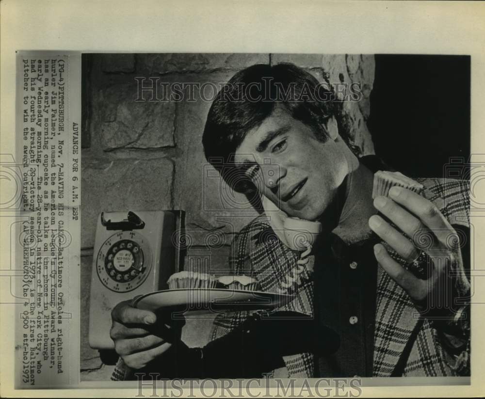 1973 Press Photo Cy Yong Award winner Jim Palmer has cupcakes while on phone. - Historic Images