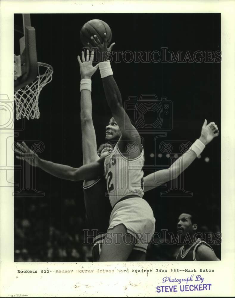 1985 Rodney McCray of the Rockets drives hard against Mark Eaton - Historic Images