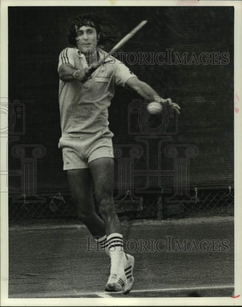 1977 Tennis player Ilie Nastase in action on the court - Historic Images