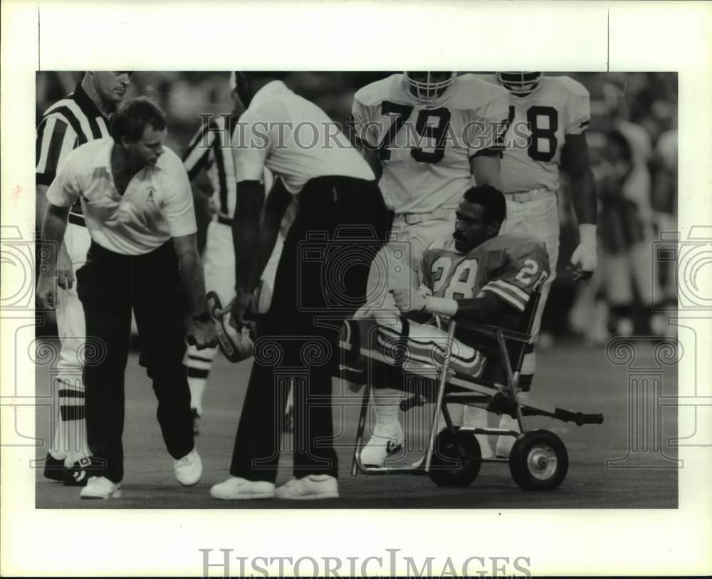 1987 Oilers' Allen Lyday is carted from field after knee injury. - Historic Images