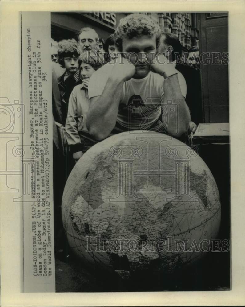 1975 European heavyweight champ Joe Bugner leans on globe in London. - Historic Images
