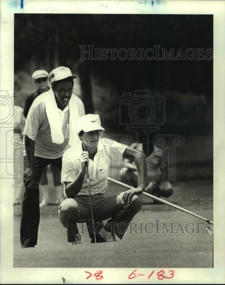 1981 Press Photo Pro golfer Jodie Mudd and caddie Henry Rice line up putt.- Historic Images