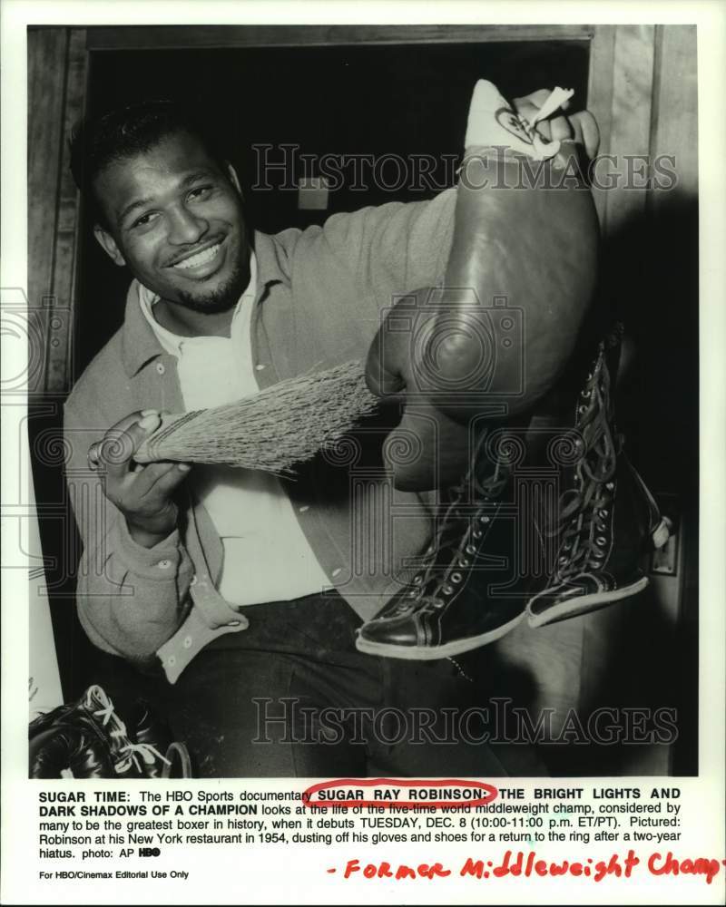 1954 Press Photo Sugar Ray Robinson dusts off gloves & shoes for return to ring. - Historic Images