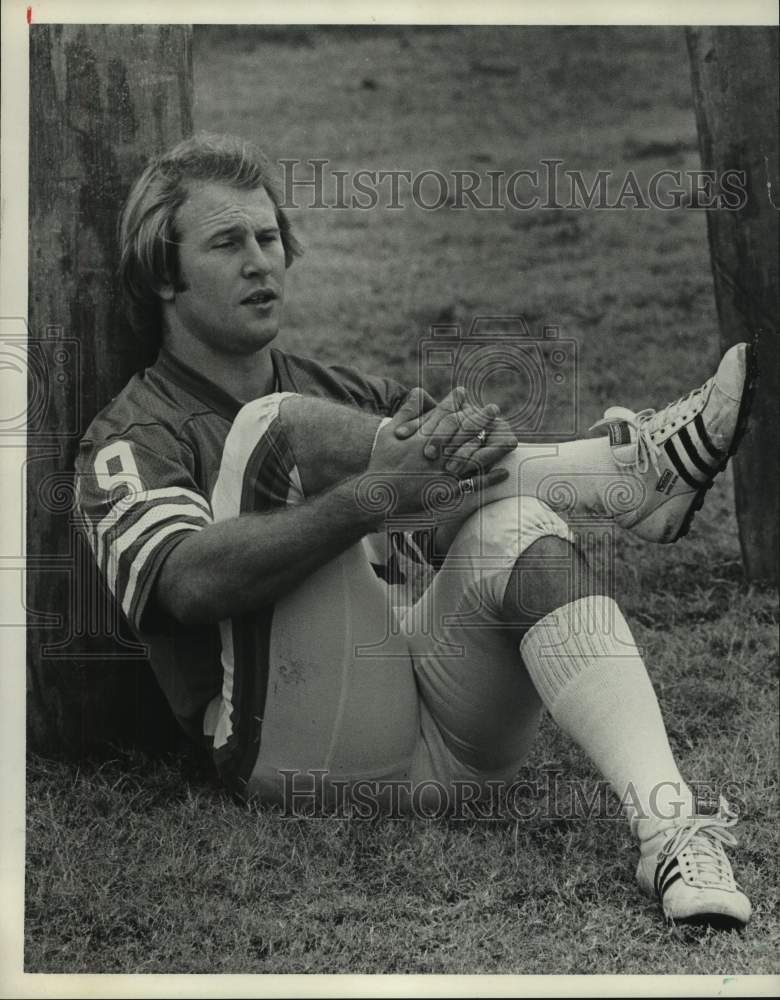 1974 Press Photo Football player Tom Smith sits against tree with legs crossed- Historic Images