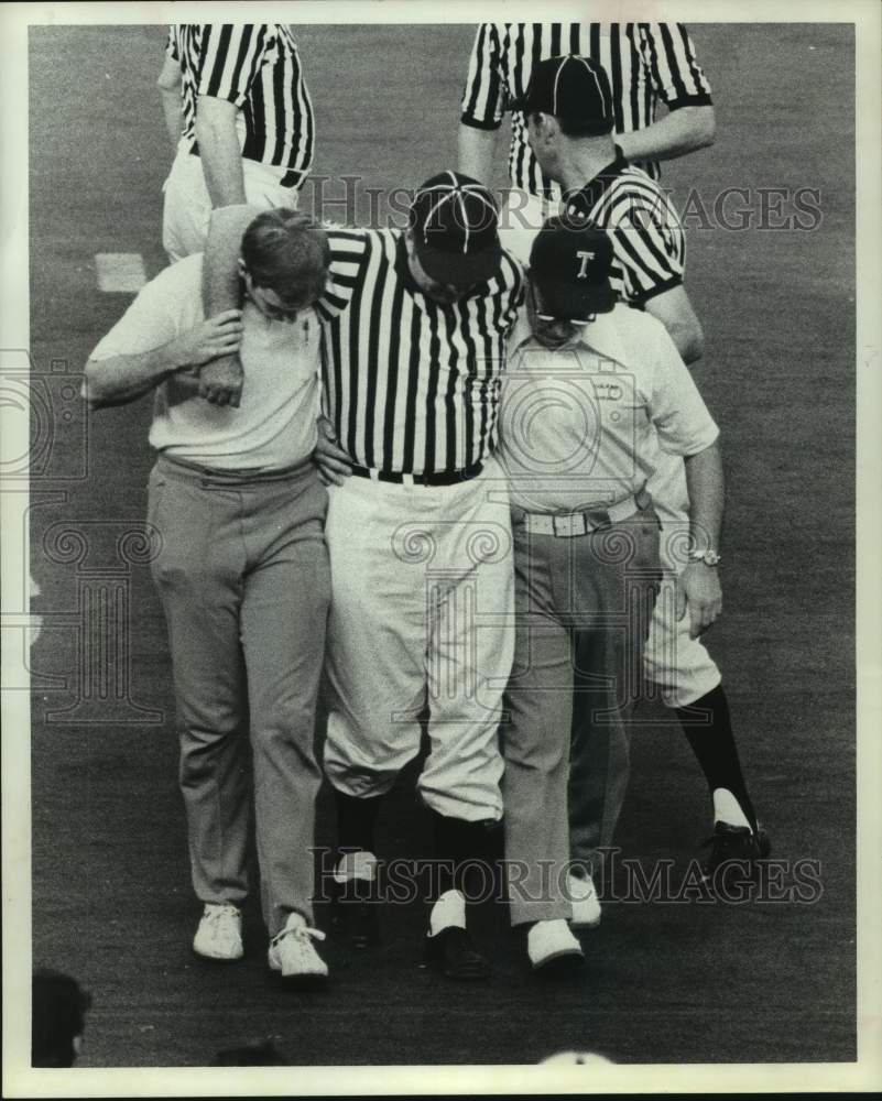 1973 Press Photo Football umpire Bruno Schroeder is helped off the field.- Historic Images