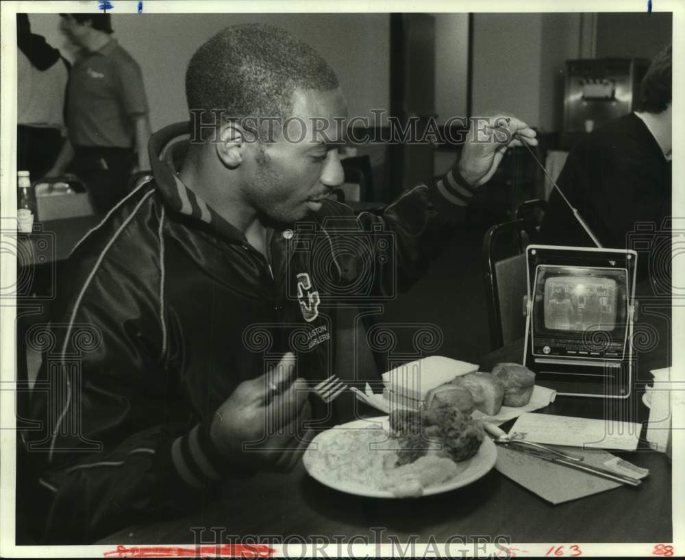 1985 Press Photo Houston Gamblers football player Gerald McNeil with food and TV- Historic Images