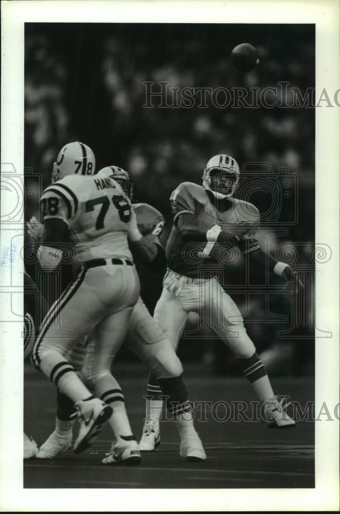 1990 Press Photo Oilers QB Warren Moon launches pass over head of Colts Jon Hand - Historic Images