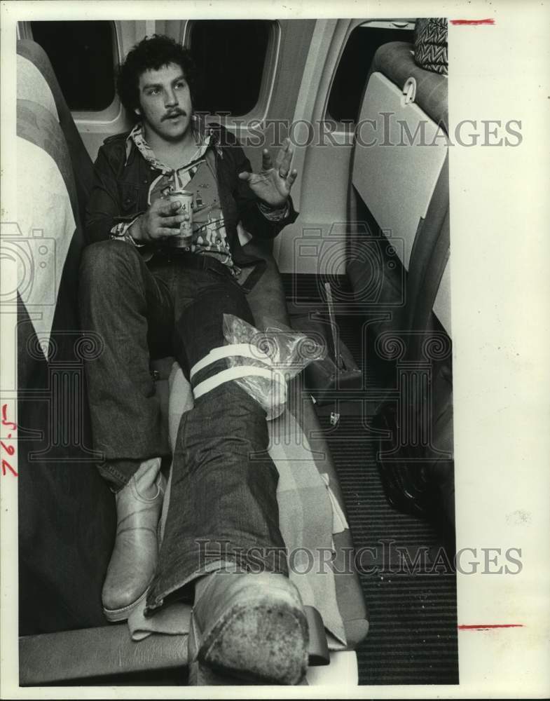 1975 Press Photo Oilers tight end John Sawyer babies knee aboard airliner - Historic Images