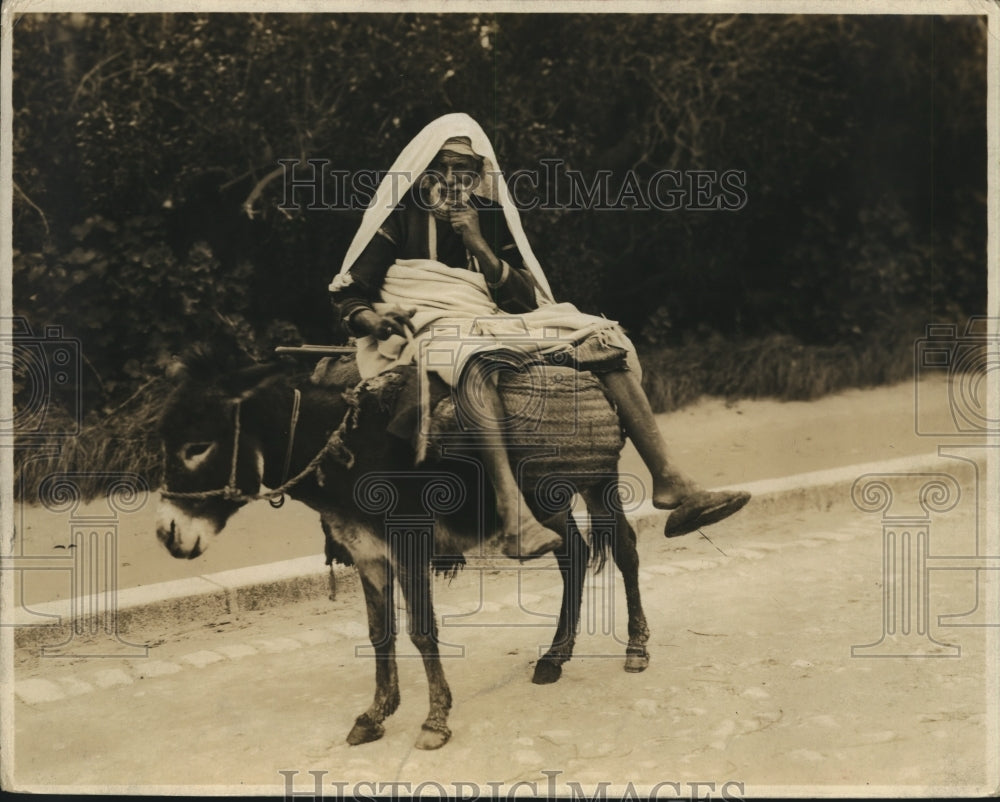 1934 A native of the progressive city of Tunis, Africa on his donkey - Historic Images