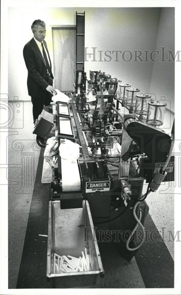 1985 Press Photo James Simonsen of Advanced Tobacco Products Inc. Checks Machine- Historic Images