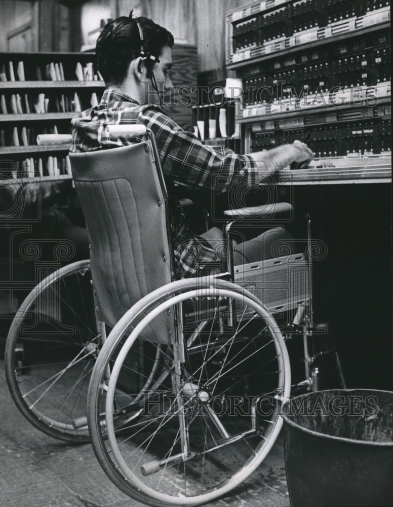 1968 Man in wheelchair works at controls, at ABAC Business Service - Historic Images