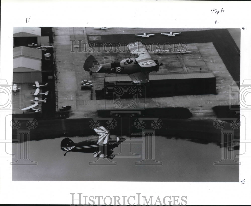 1992 Two aerobatic biplanes fly over Hooks Airport, Texas - Historic Images