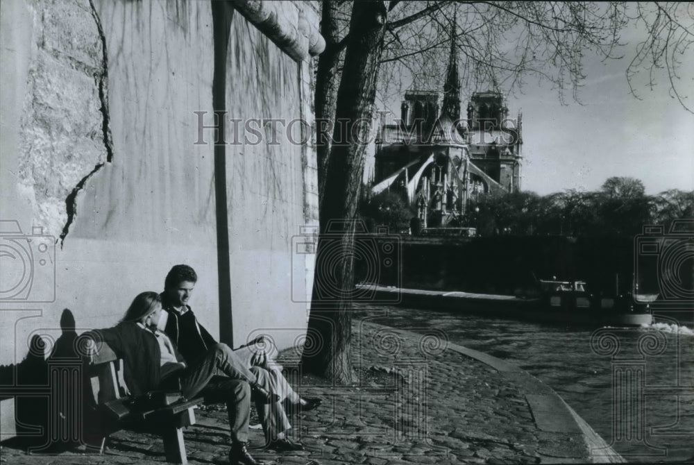 1982 tourist sitting outside the Notre Dame Cathedral in Paris - Historic Images