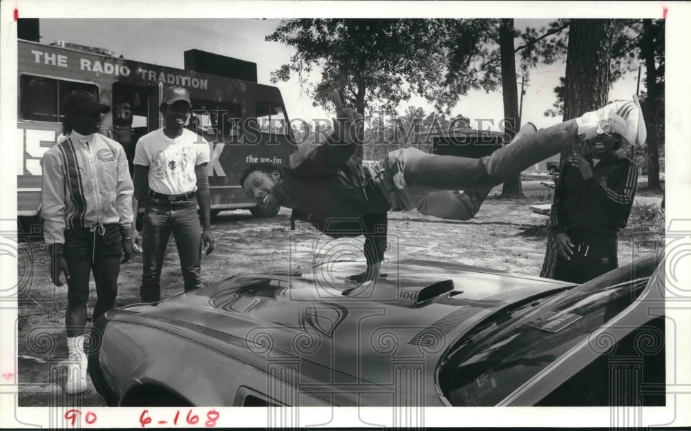 1984 Man Dances on Hood of Car As Friends Watch. - Historic Images