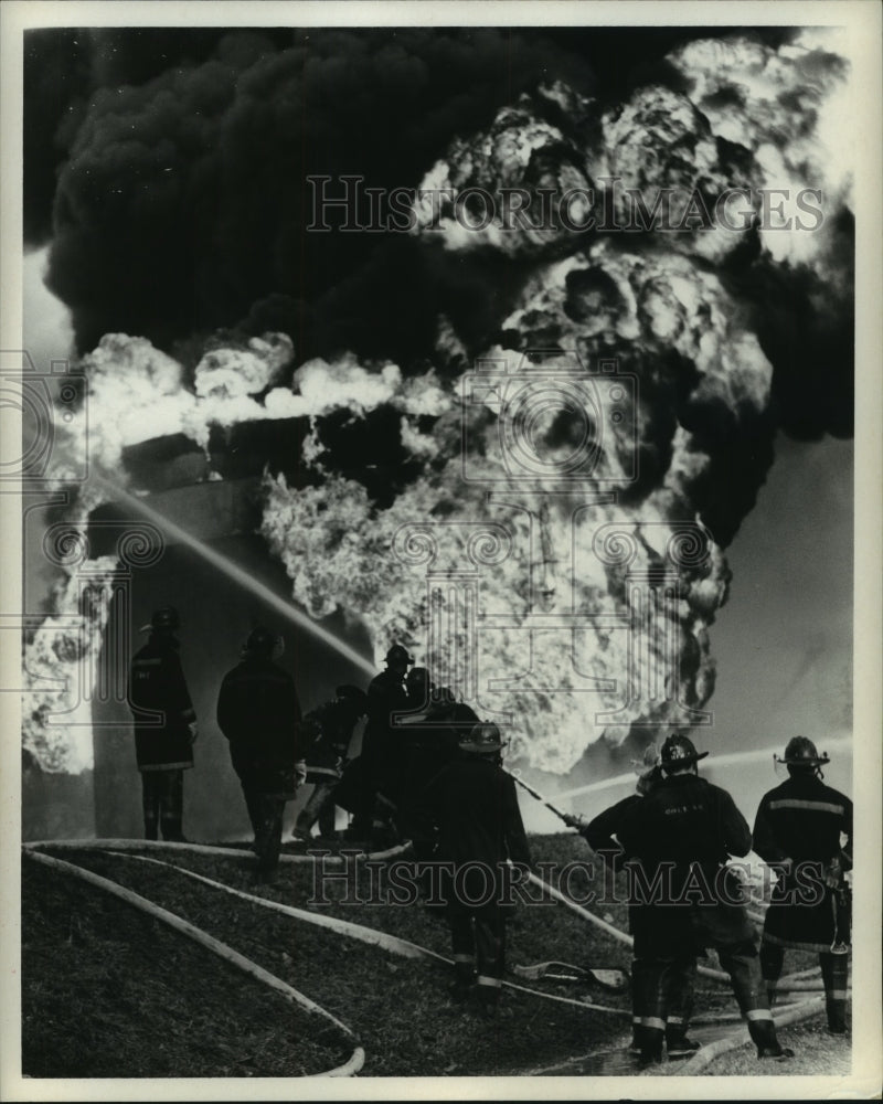 1969 Press Photo Firemen spray water on fire at Mobile Oil Corp. - hcx10608-Historic Images