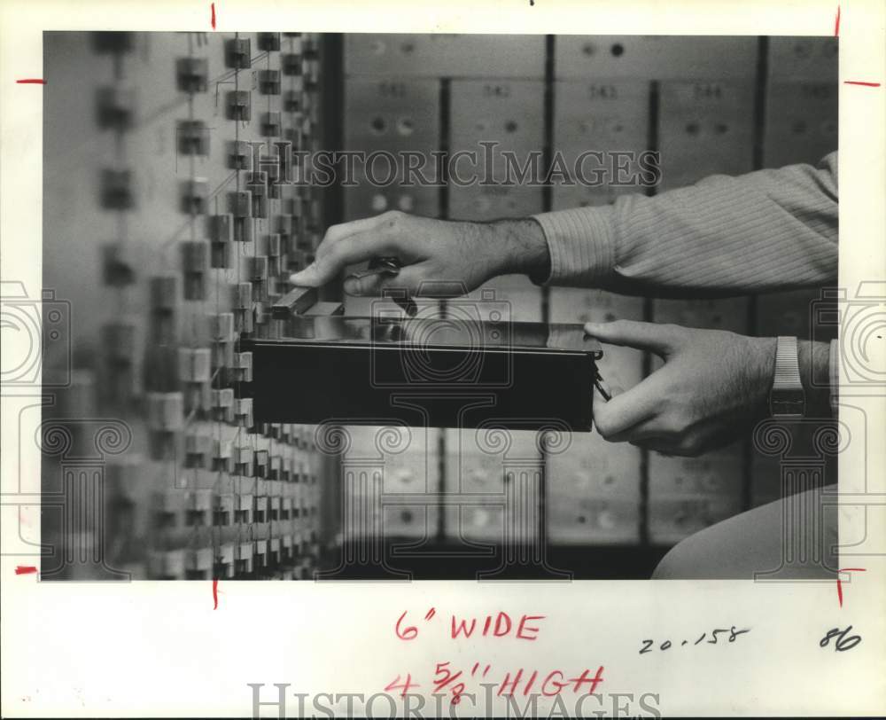 1981 Person holds safe deposit box in a bank - Historic Images
