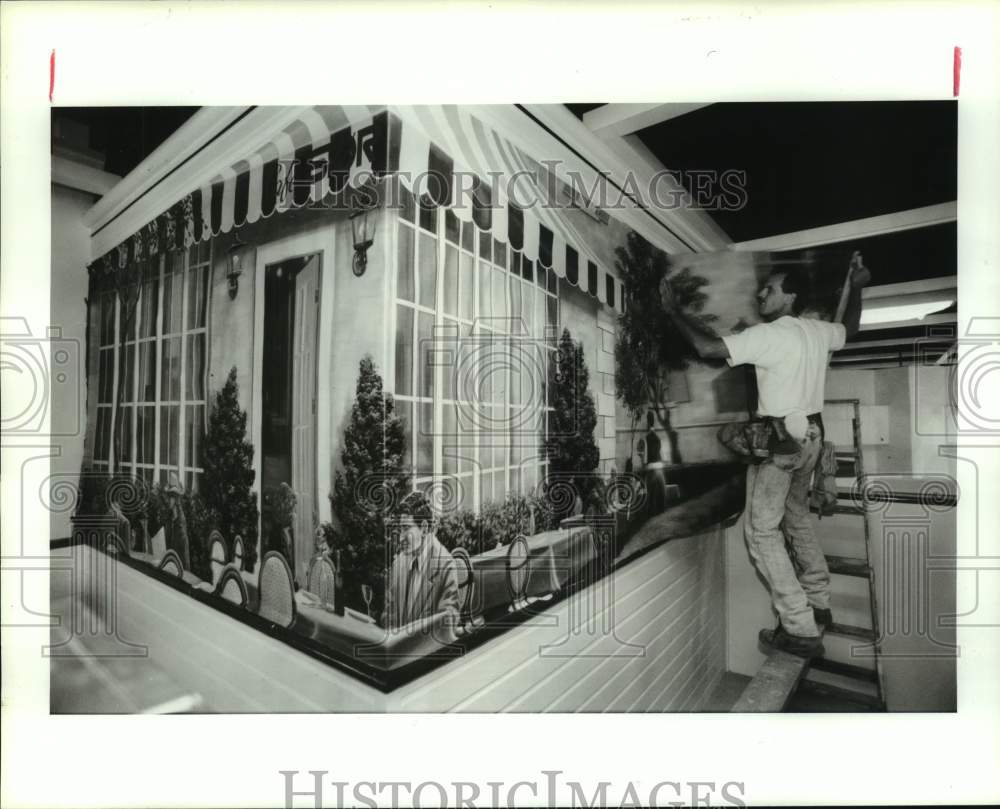 1991 Press Photo Gordon Williams hangs mural at Stor store in Houston - Historic Images