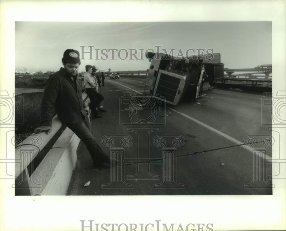 1989 Press Photo Truck driver Garry Ingram by overturned truck on Houston road - Historic Images