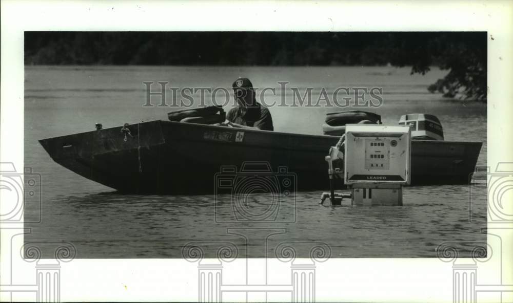1990 Press Photo Boater Harry Adkins sees flooded gas pump along Trinity River - Historic Images
