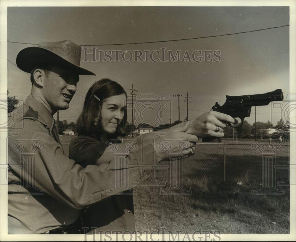 1972 TX Officer J.L. Tillinghast helps Veronica Kroboth with gun - Historic Images