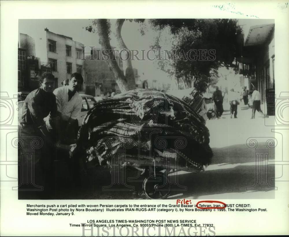 1995 Merchants push a cart with Persian carpets-Tehran, Iran - Historic Images
