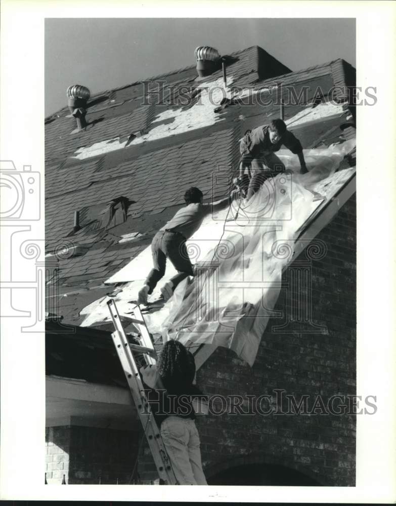 1992 Chris Boyce neighbors help cover roof after tornado in Houston - Historic Images