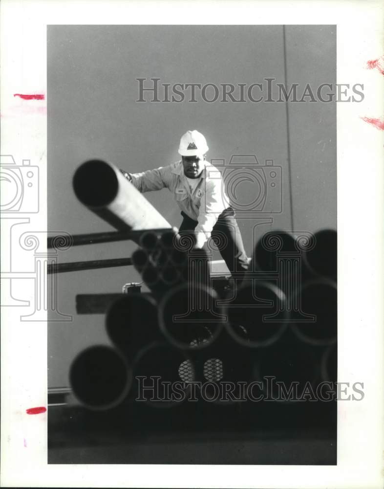 1990 Press Photo Employee Avie Skyler loads pipe at Wallace Co. in Houston - Historic Images