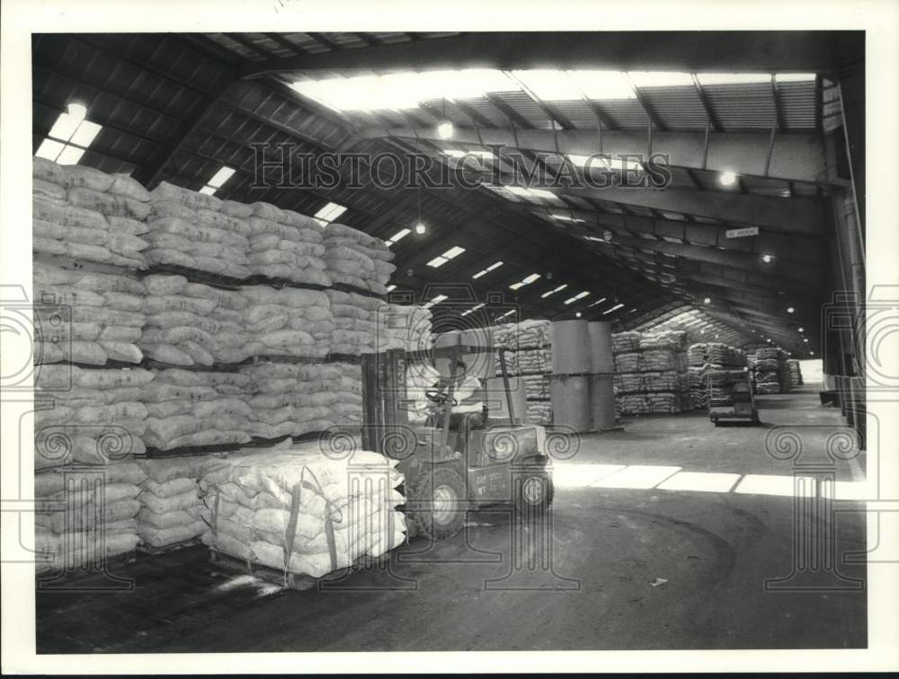 1991 Press Photo Employees Use Forklifts to Move Bags in Warehouse - Historic Images