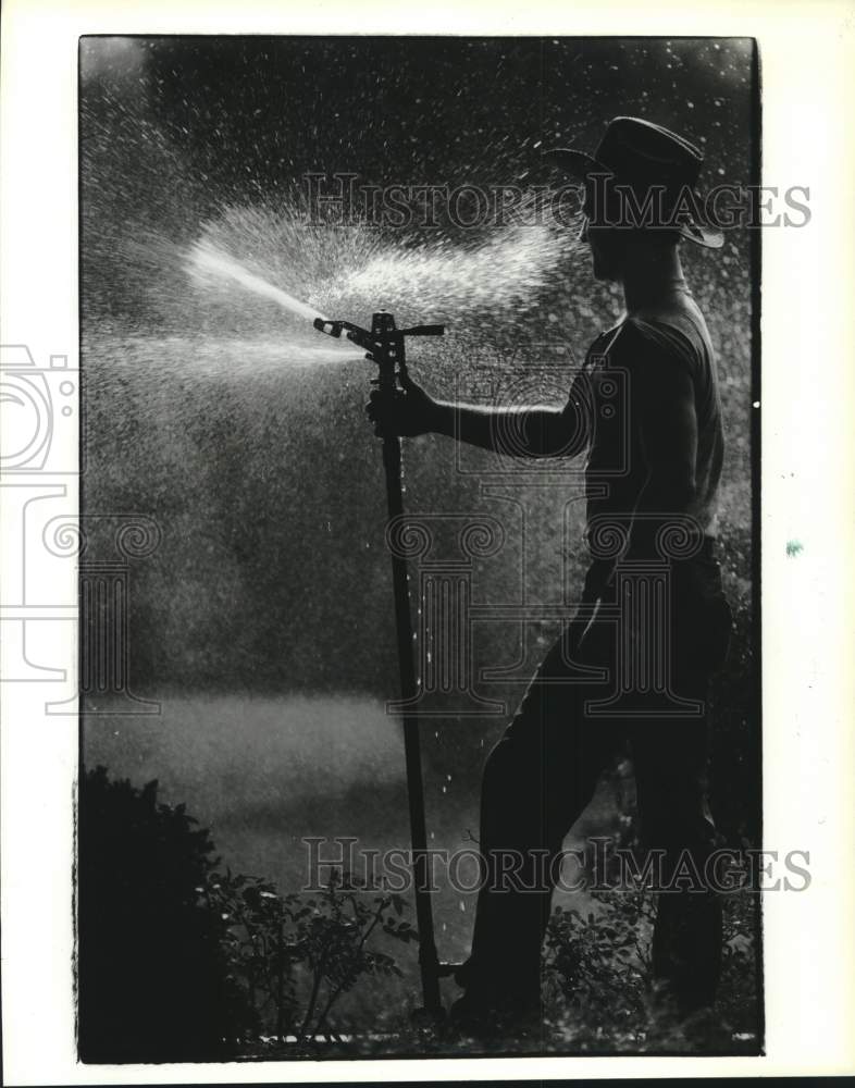 1990 Press Photo Mark Rosenberg turns on a sprinkler at Houston Garden Center - Historic Images