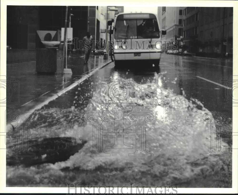 1986 Press Photo Bus Approaches as Water Blows from Manhole in Rain, Houston - Historic Images