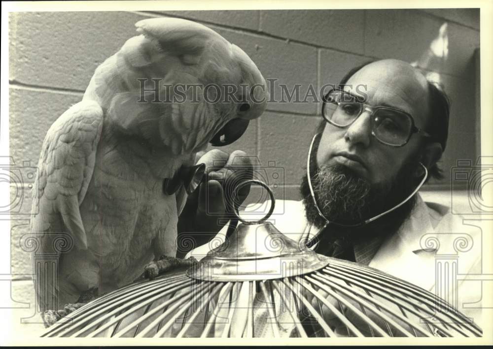 1981 Press Photo Dr. Wilber Amand examines cockatoo at Philadelphia Zoo - Historic Images
