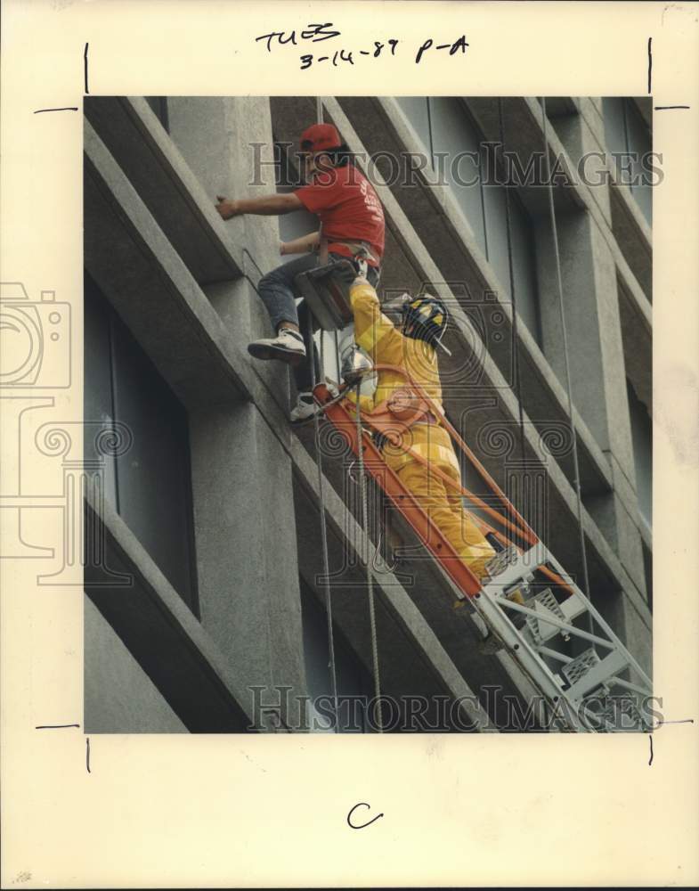 1989 Press Photo Houston Firefighter Randy Fisher Helps Frightened Ray Trevino - Historic Images