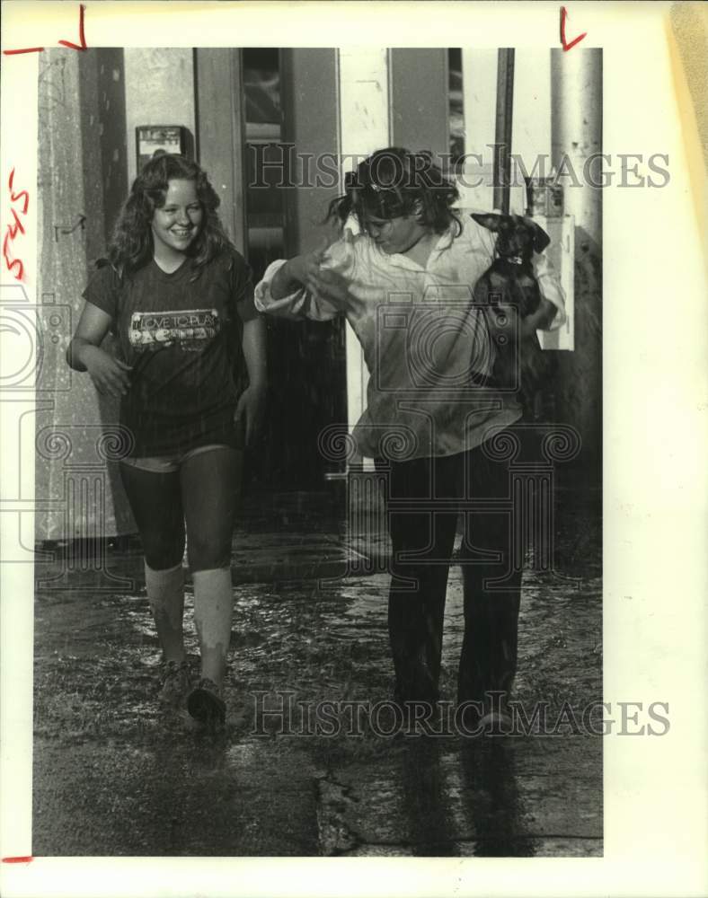 1982 Press Photo Stacey Colca and Jessica Farmer caught in downpour in Houston - Historic Images