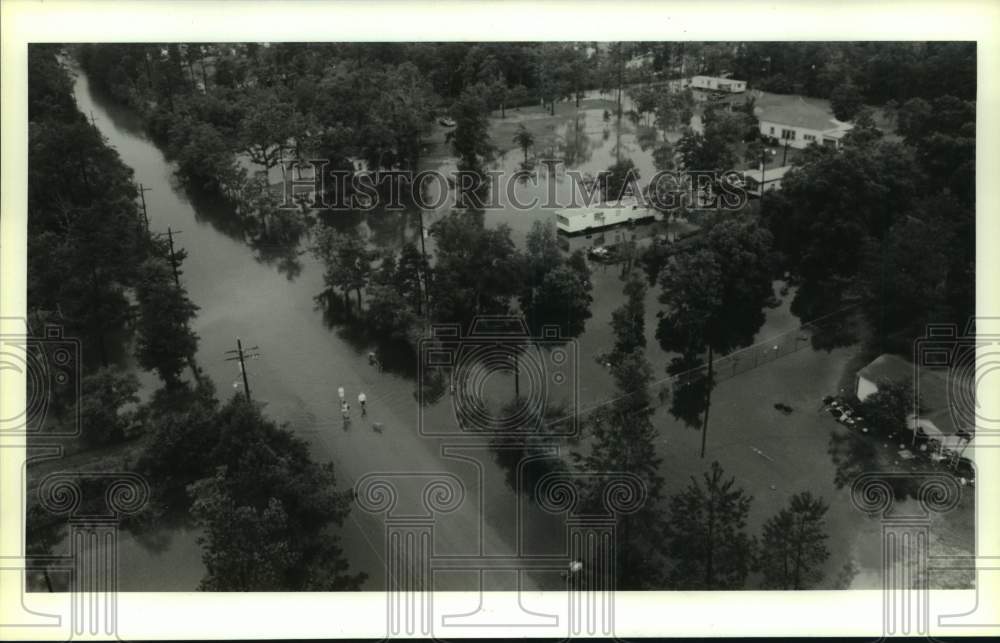 1987 Press Photo Residents of New Caney Wade Down Flooded Streets Near Houston - Historic Images