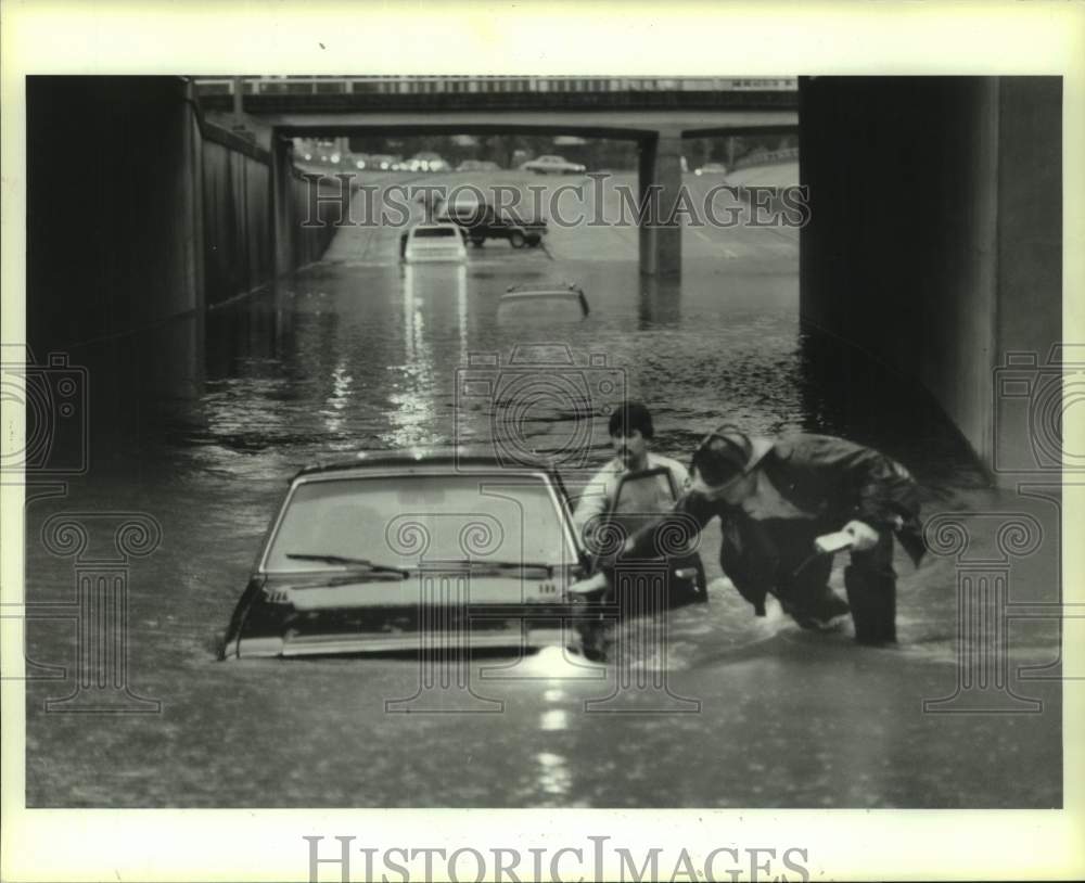 1985 Firemen check for occupants of flooded cars on Allen in Houston - Historic Images