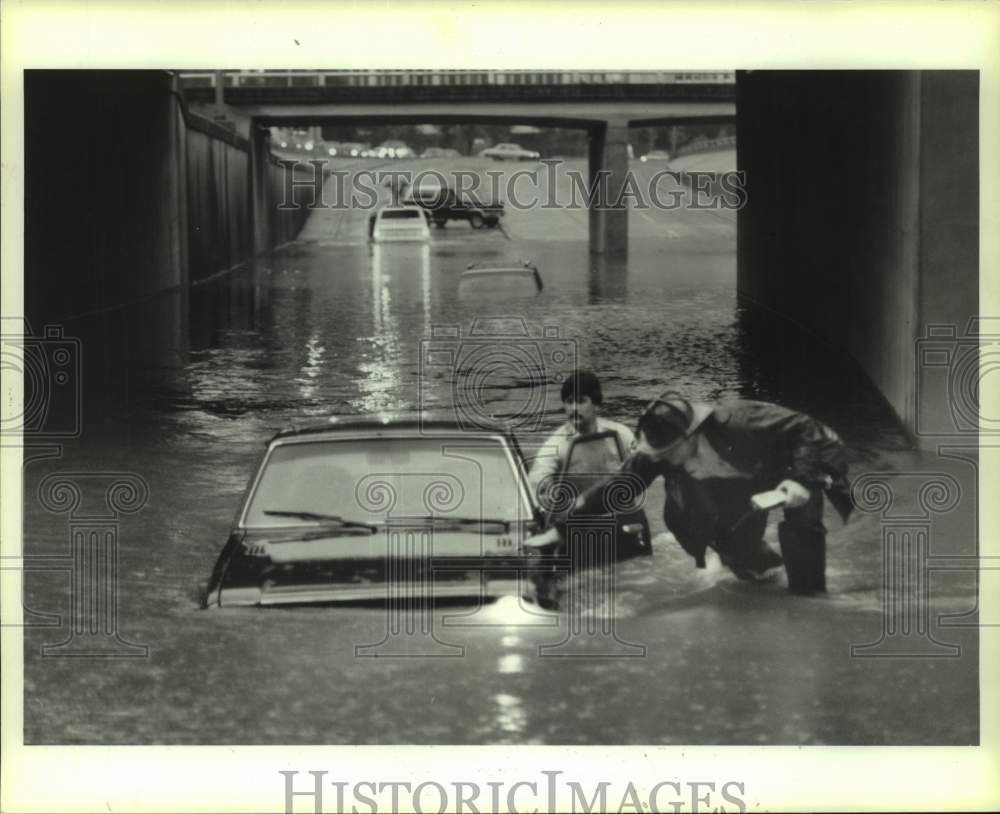 1985 Firemen check for occupants of flooded cars on Allen in Houston - Historic Images