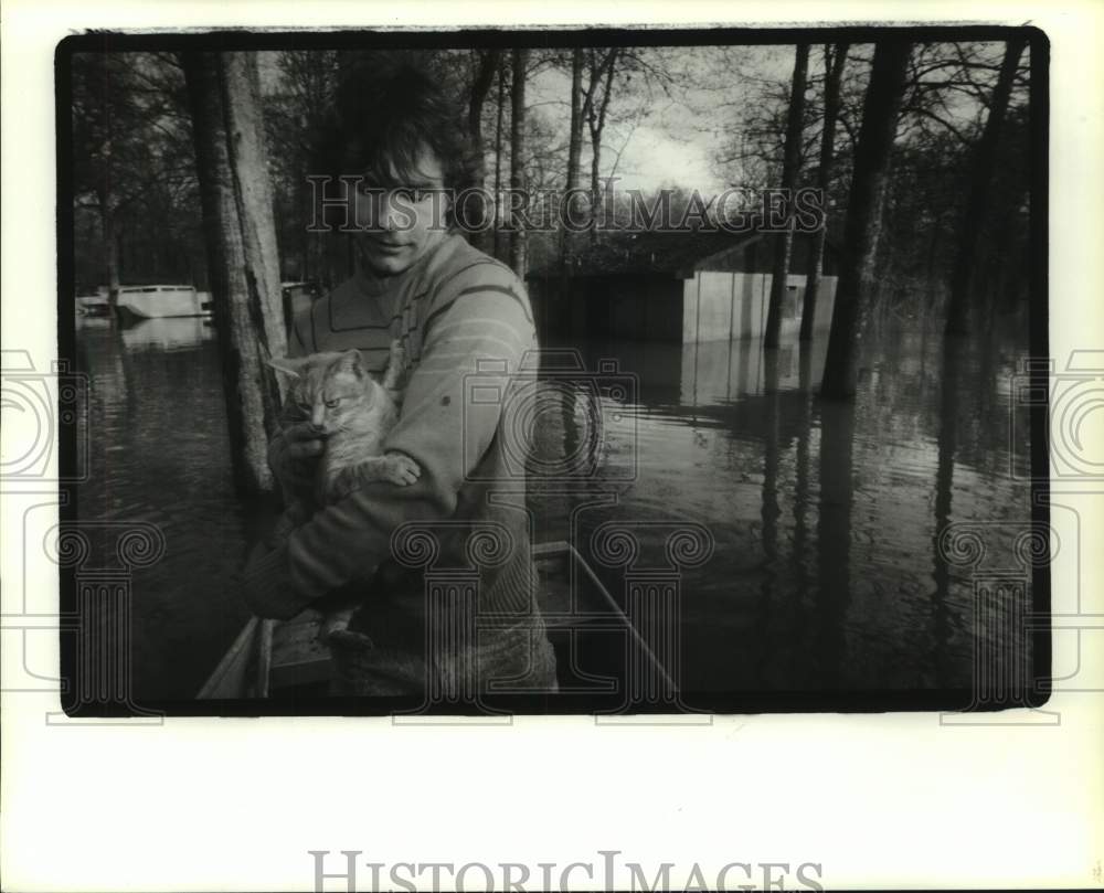 1991 Donald Kelley rescues cat from atop flooded house in Texas - Historic Images