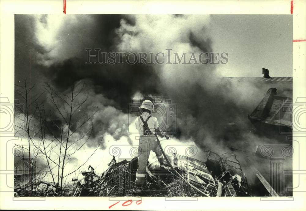 1978 Houston firefighter sprays burning tires - Dowling Auto Center - Historic Images