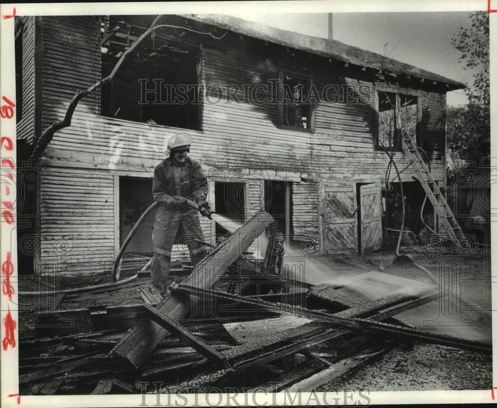 1977 Press Photo Firefighter Sprays Vacant building in Houston - Historic Images