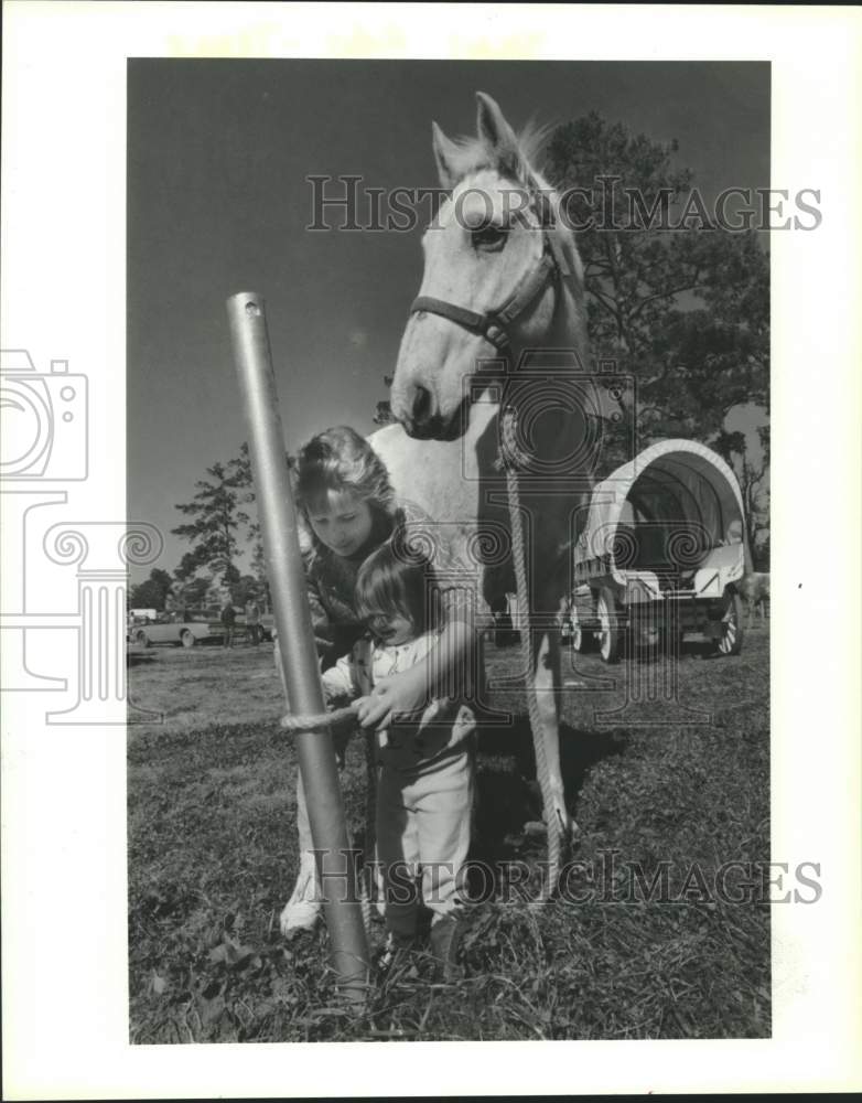 1989 Girls tie up horse - Trinity Valley Trail Riders in Liberty, TX - Historic Images