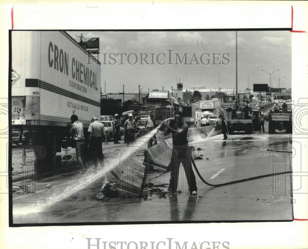 1985 Press Photo Fireman hoses down spilled fuel - Truck accident in Houston - Historic Images