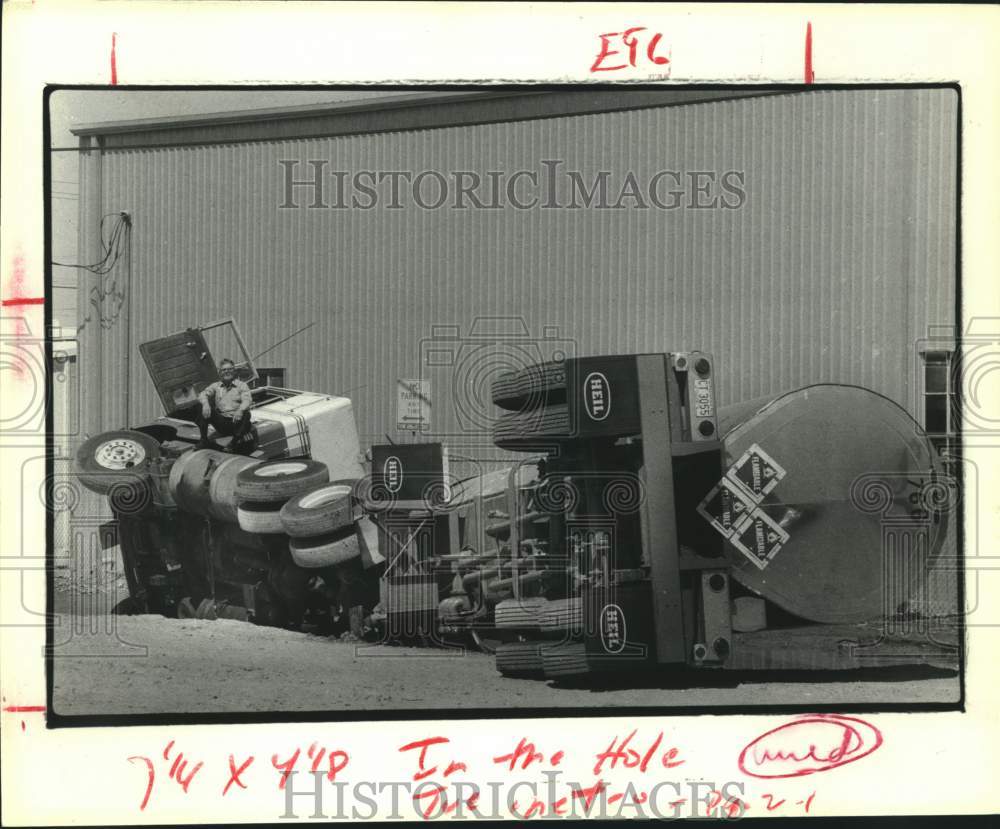 1979 Press Photo Driver for AZS Chemical Co. sits on overturned truck in Houston - Historic Images