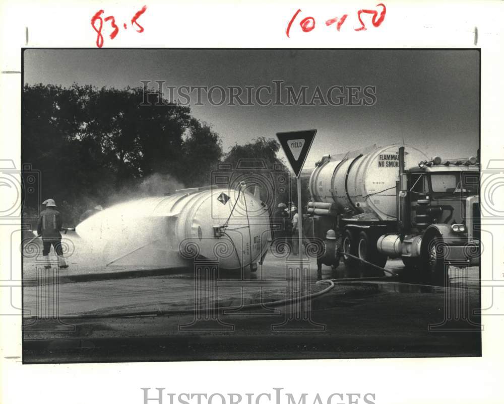 1980 Press Photo Firemen hose down overturned tank truck in Houston - Historic Images